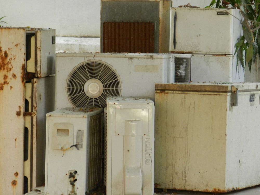 Various discarded household appliances, including a weathered refrigerator — Professional Scrap Metal Recycling in Winnellie, NT