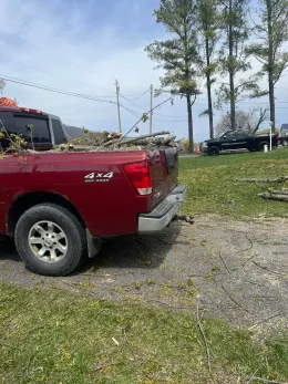 A red truck is parked in a grassy field.