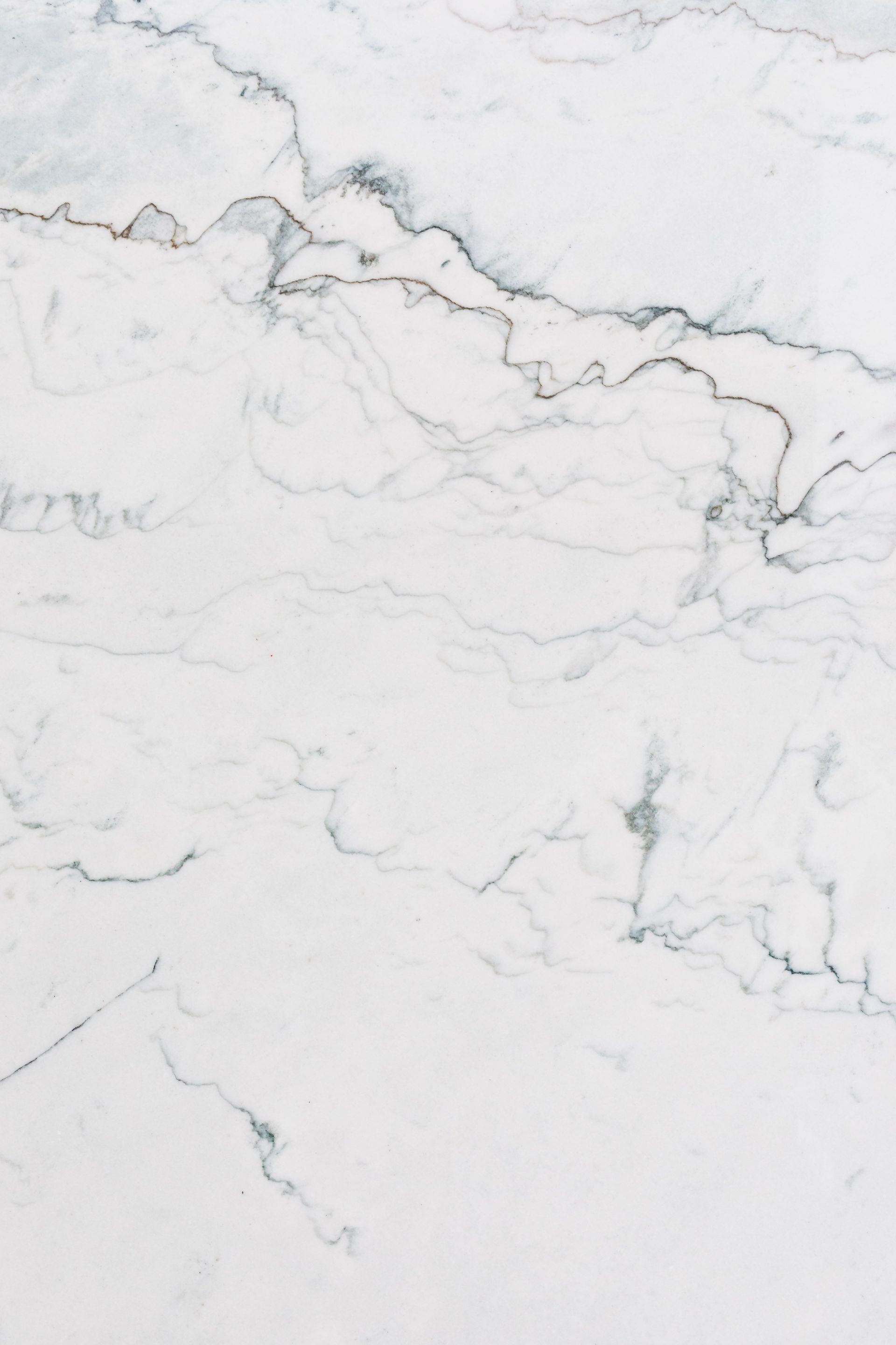 White marble surface with gray veining and subtle gold accents