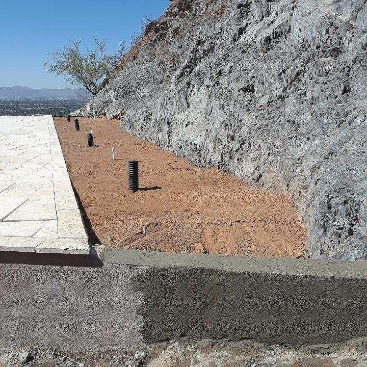 A concrete walkway is being built on the side of a hill.