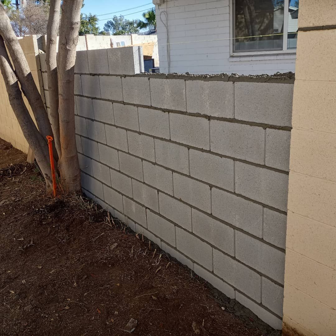 A brick wall with a tree in the background