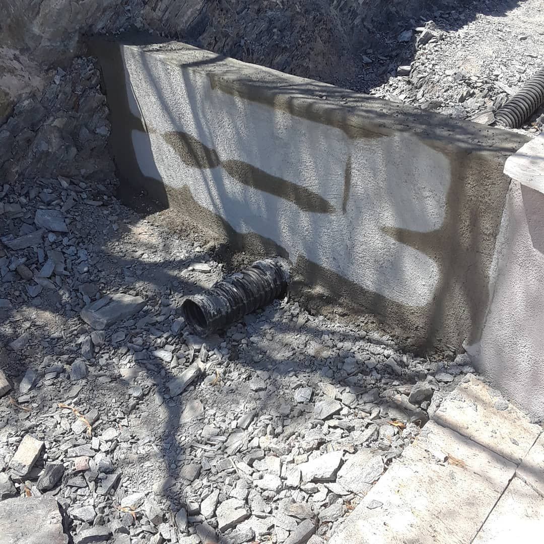 A large concrete block is sitting in a pile of rocks