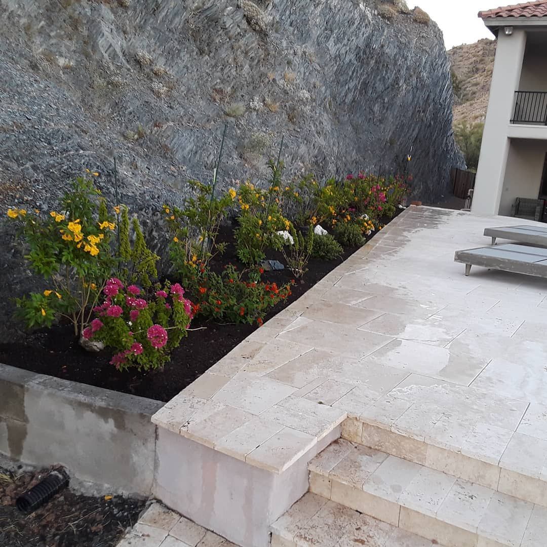A patio with flowers and stairs leading up to it