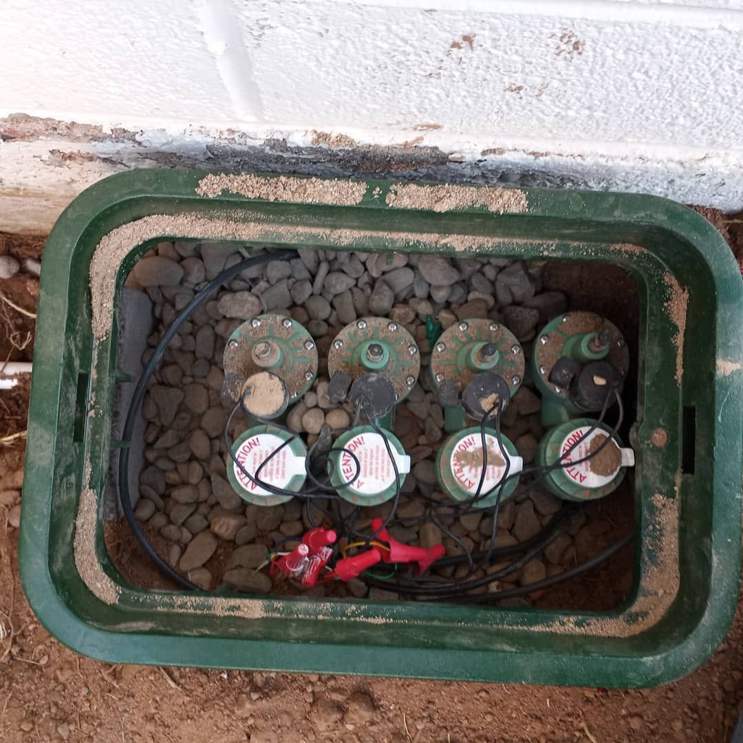 A green box filled with water meters is sitting on the ground.