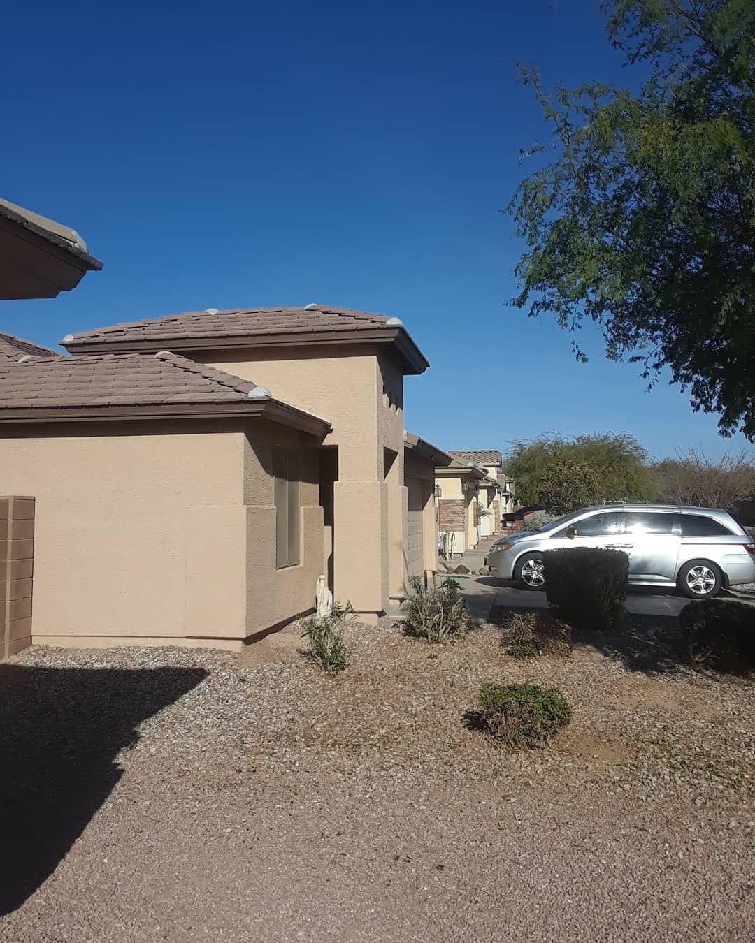 Two cars are parked in front of a house on a sunny day