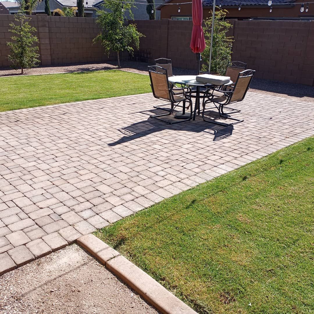 A patio with a table and chairs and an umbrella