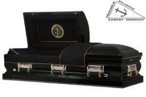 Black casket with open lid, gold trim, handles, and a military emblem.