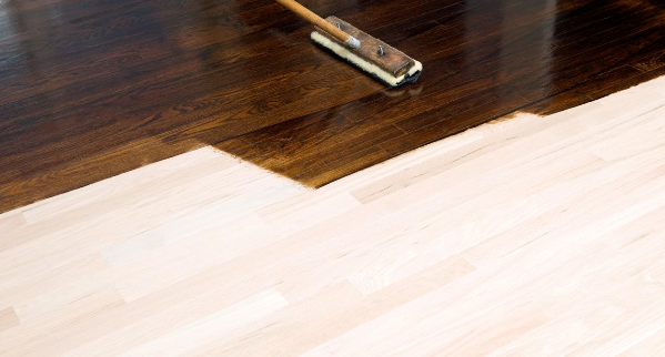 Sanded wood floor being stained.