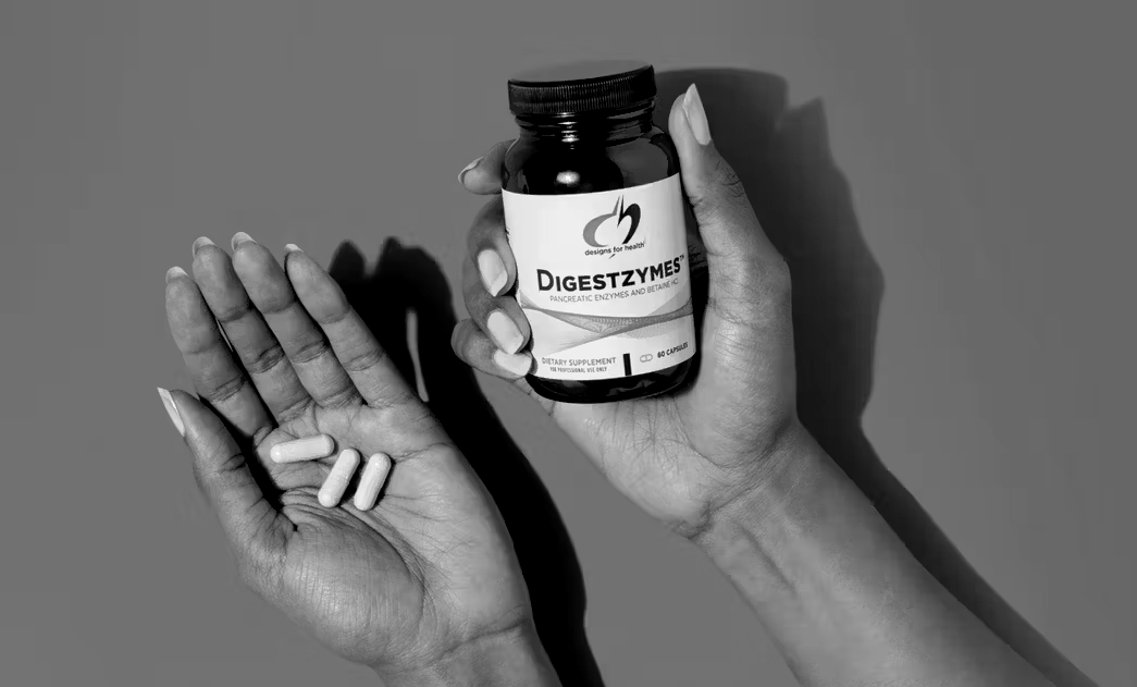 Person holding a bottle of capsules, with capsules in their open palm.
