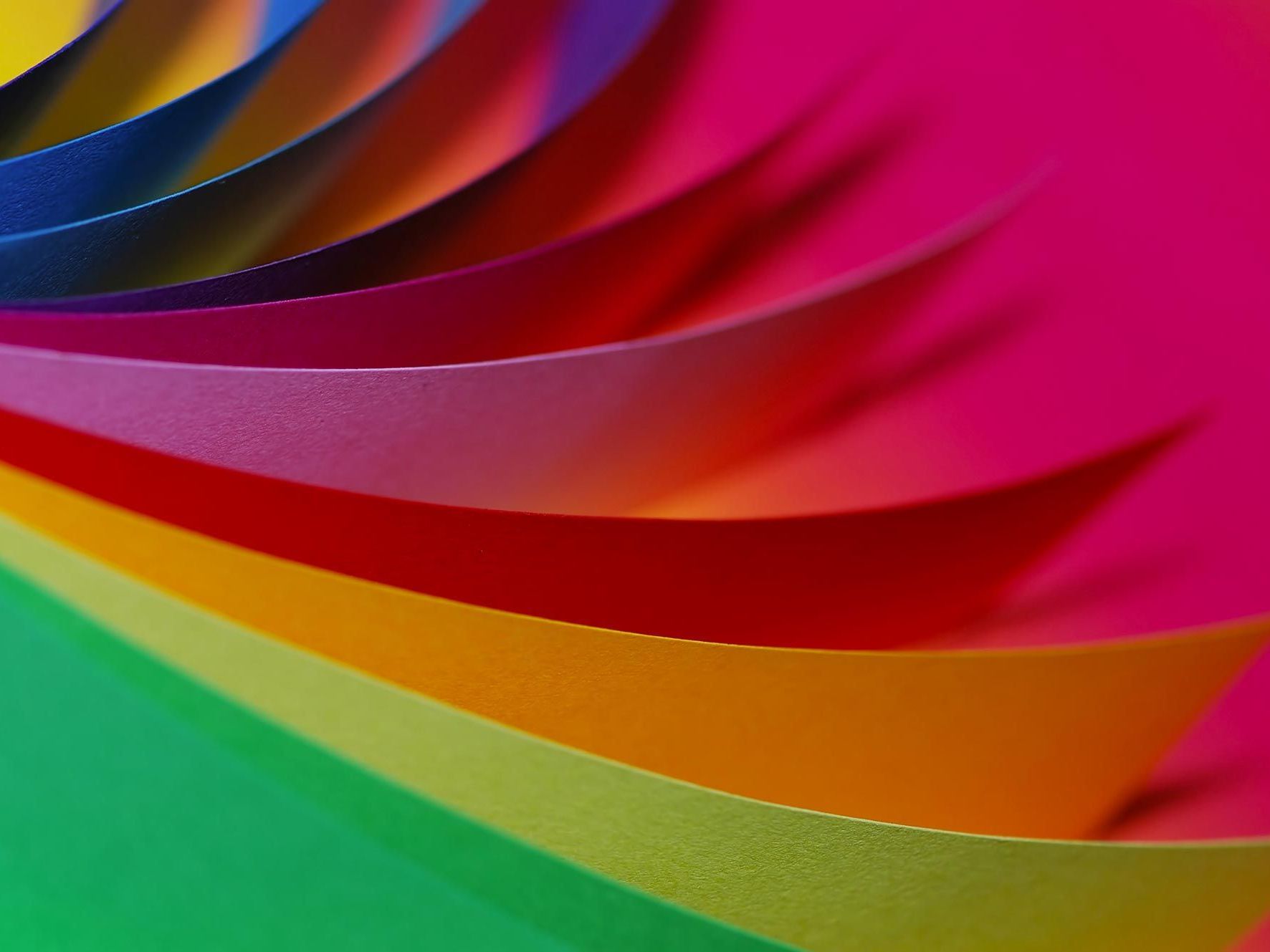 A close up of a rainbow of colored paper