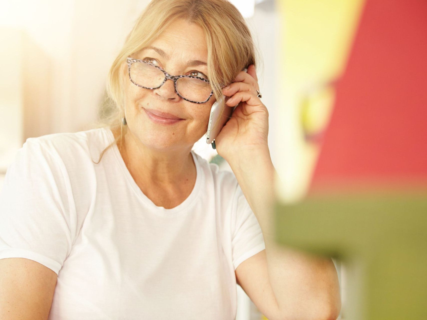 A woman wearing glasses is talking on a cell phone.