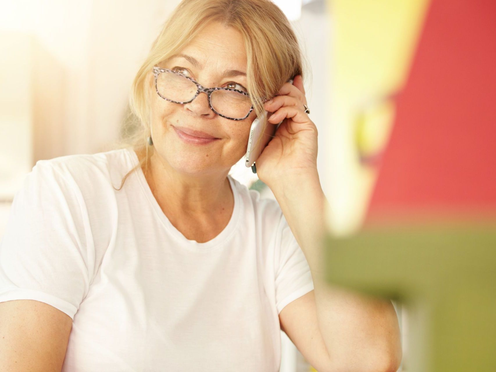 A woman wearing glasses is talking on a cell phone.