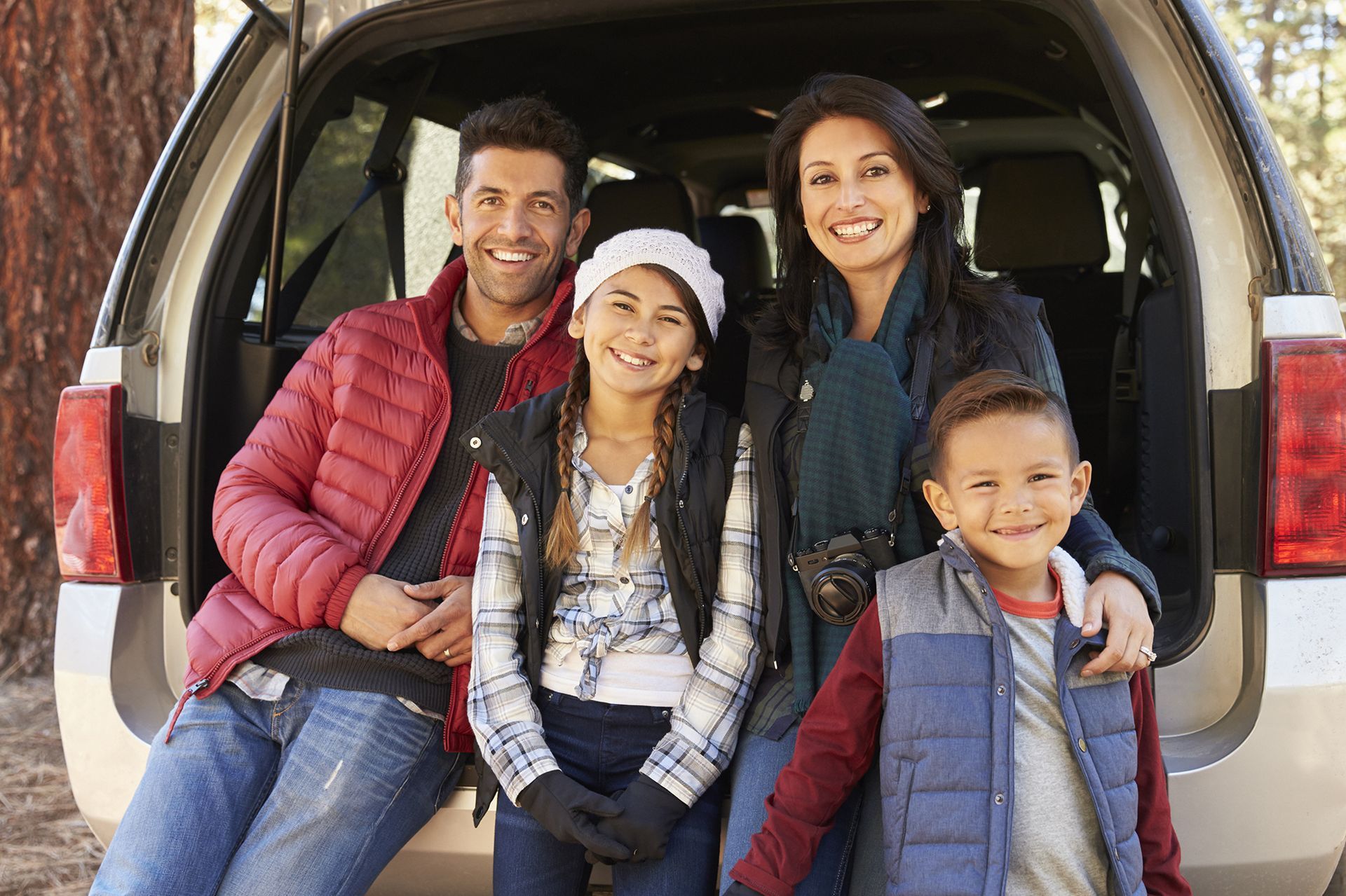 Happy Family Sitting at the Back of Their Car