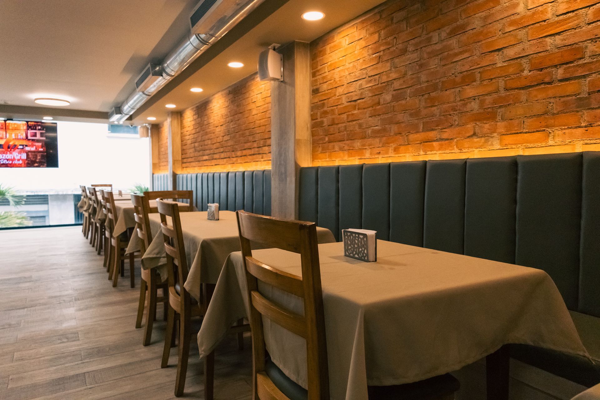 A restaurant with tables and chairs and a brick wall