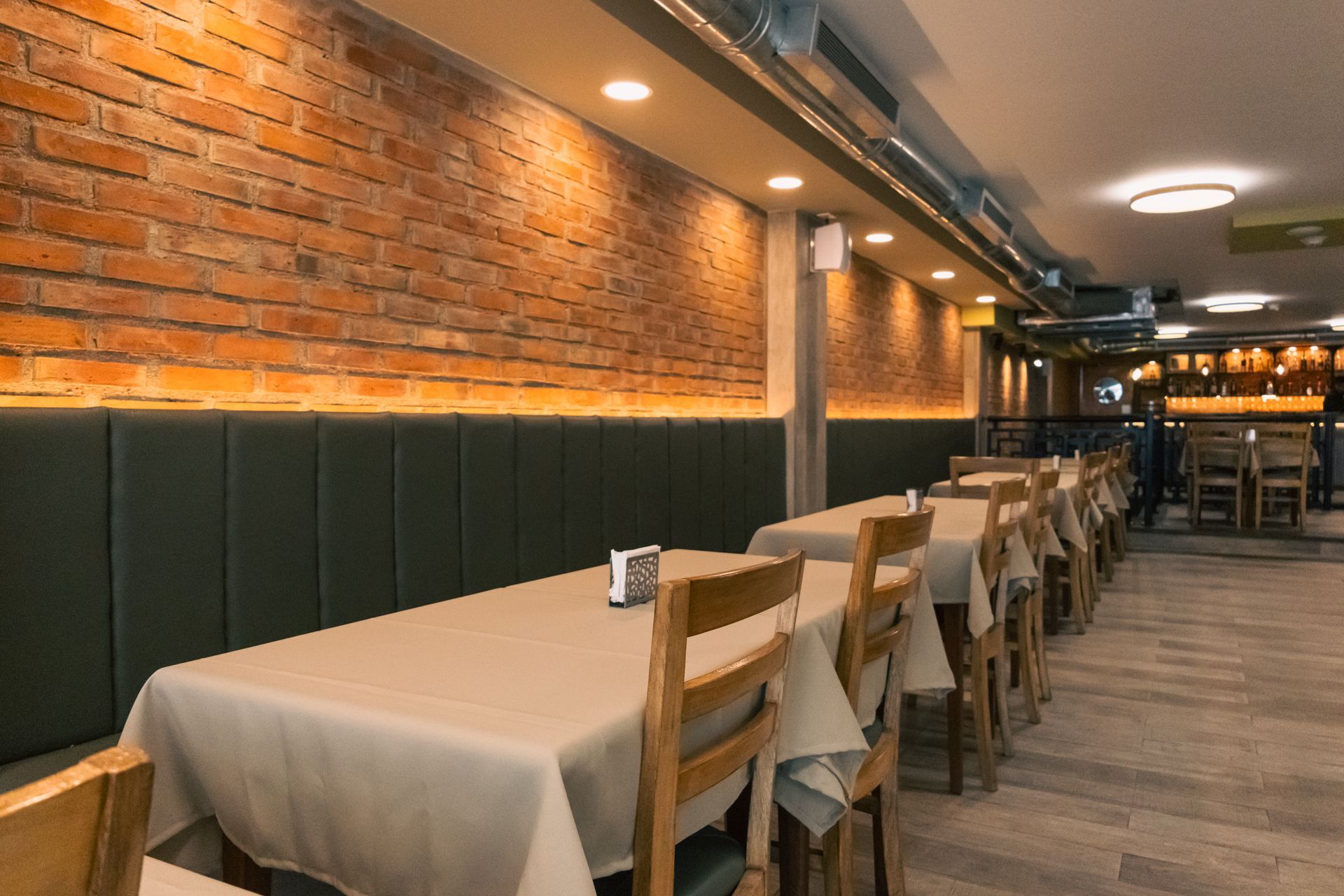 A restaurant with tables and chairs and a brick wall