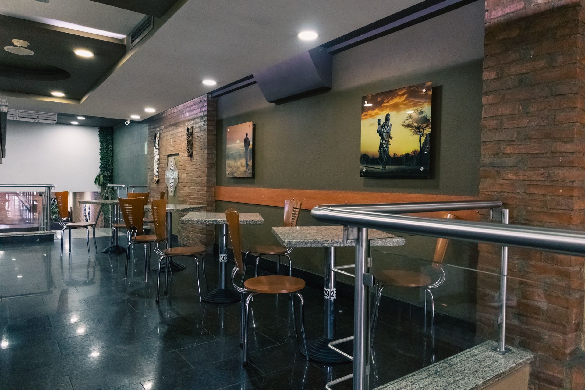 A restaurant with tables and chairs and a painting on the wall