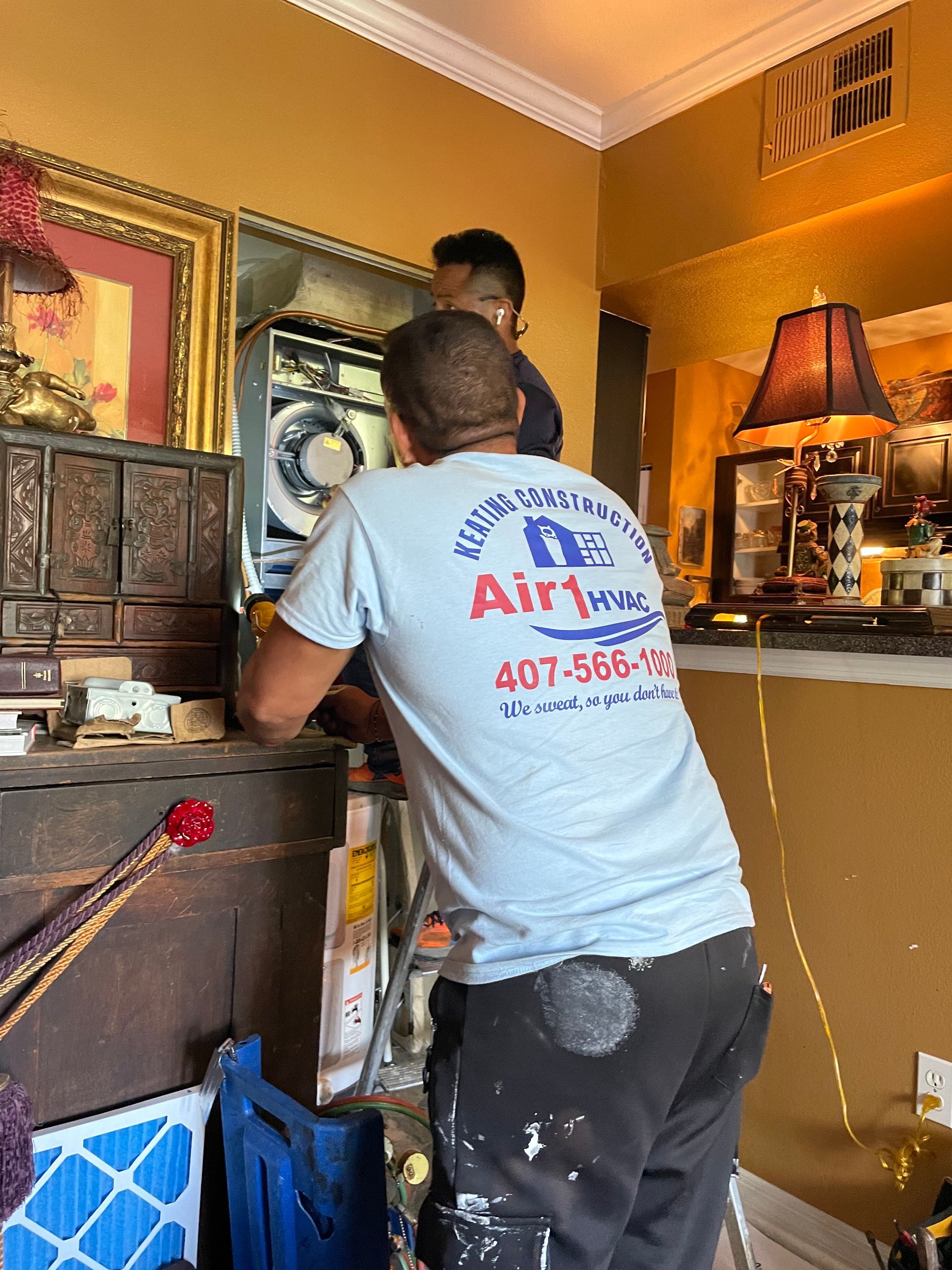 a man is working on an air conditioner in a living room .