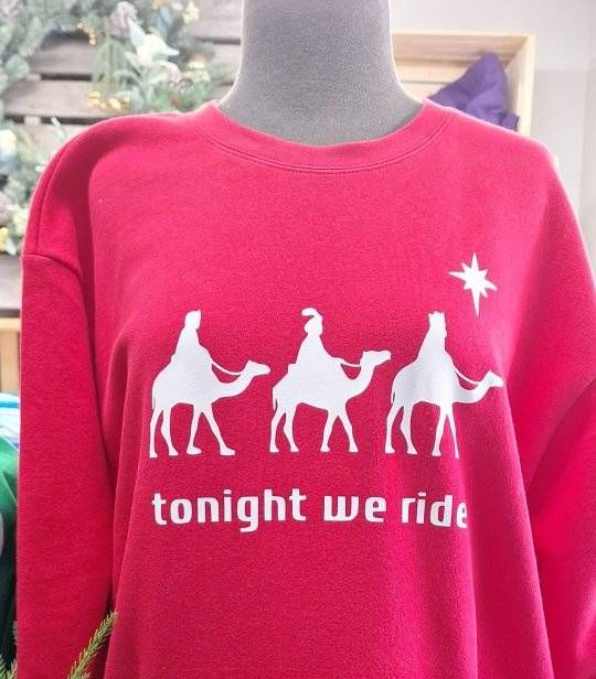 Red sweatshirt with white graphic of three wise men on camels, text