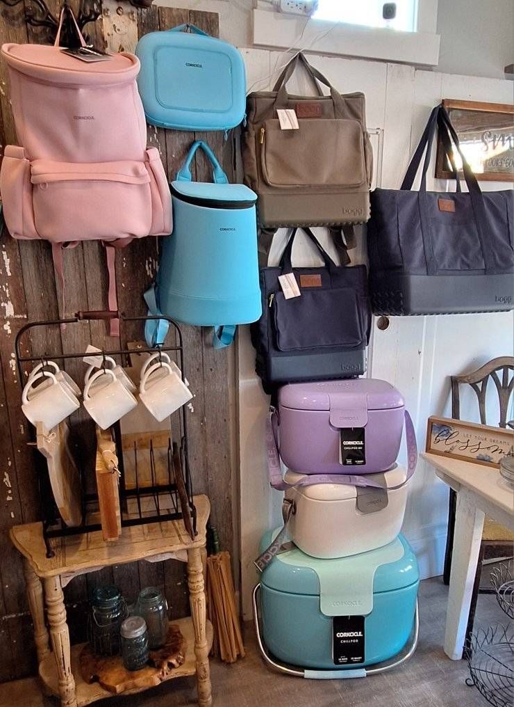 Display of various colored bags and containers hanging on a rustic wall.