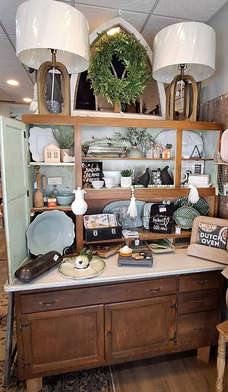 A white boat is parked in the grass next to a yellow ladder.