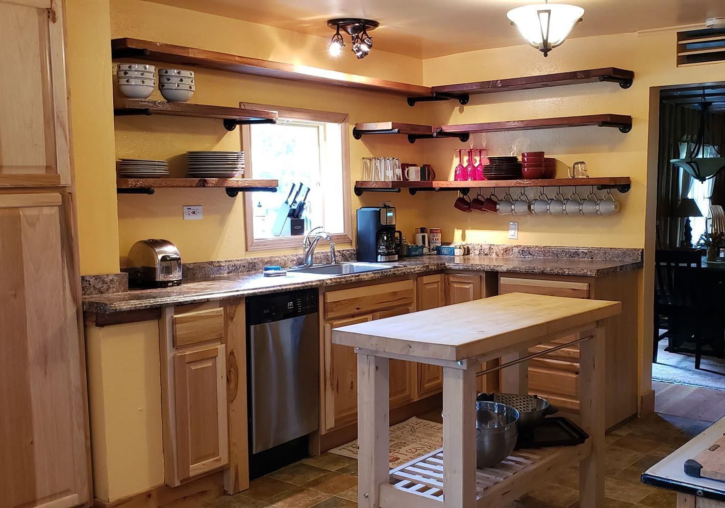 A kitchen with stainless steel appliances , wooden cabinets , and a wooden island.