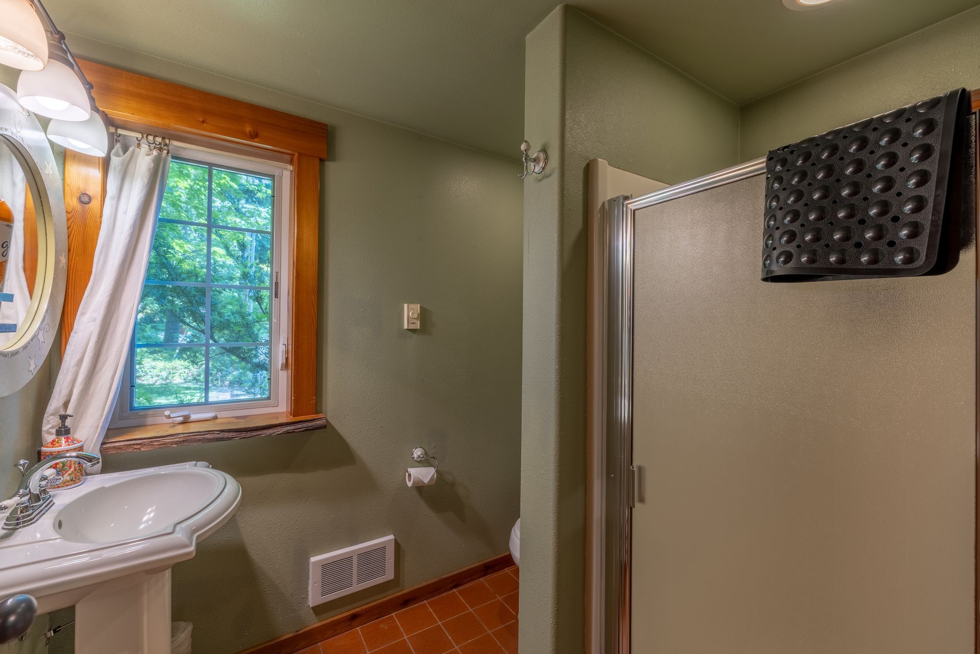 A bathroom with a sink , toilet and shower.