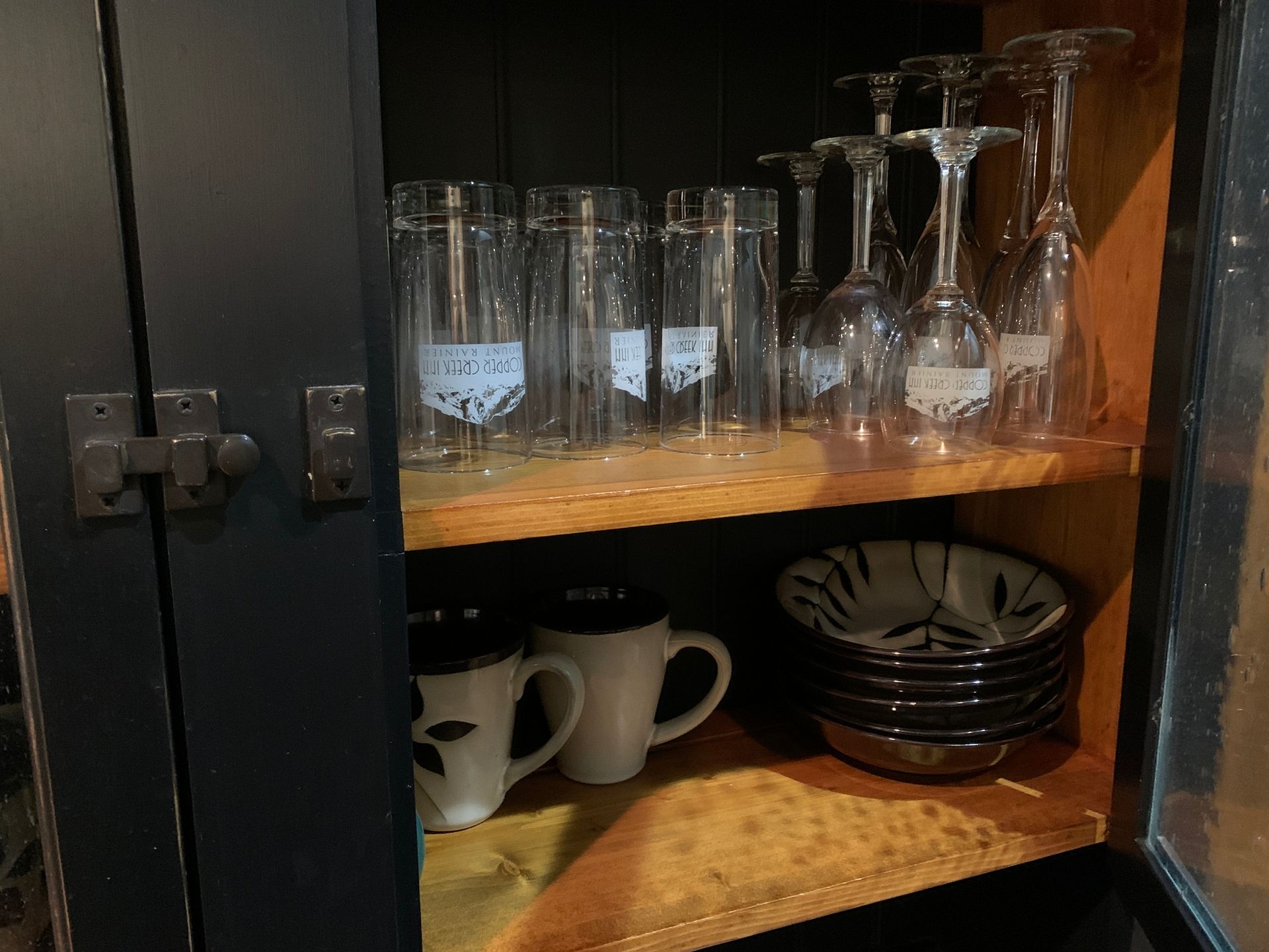 A cabinet filled with glasses , cups , and bowls.