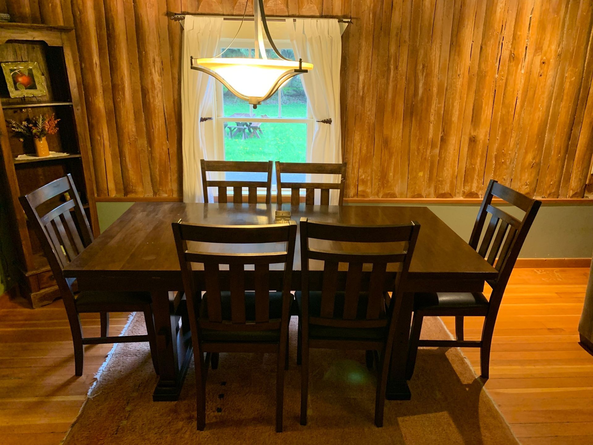 A dining room table and chairs in front of a window