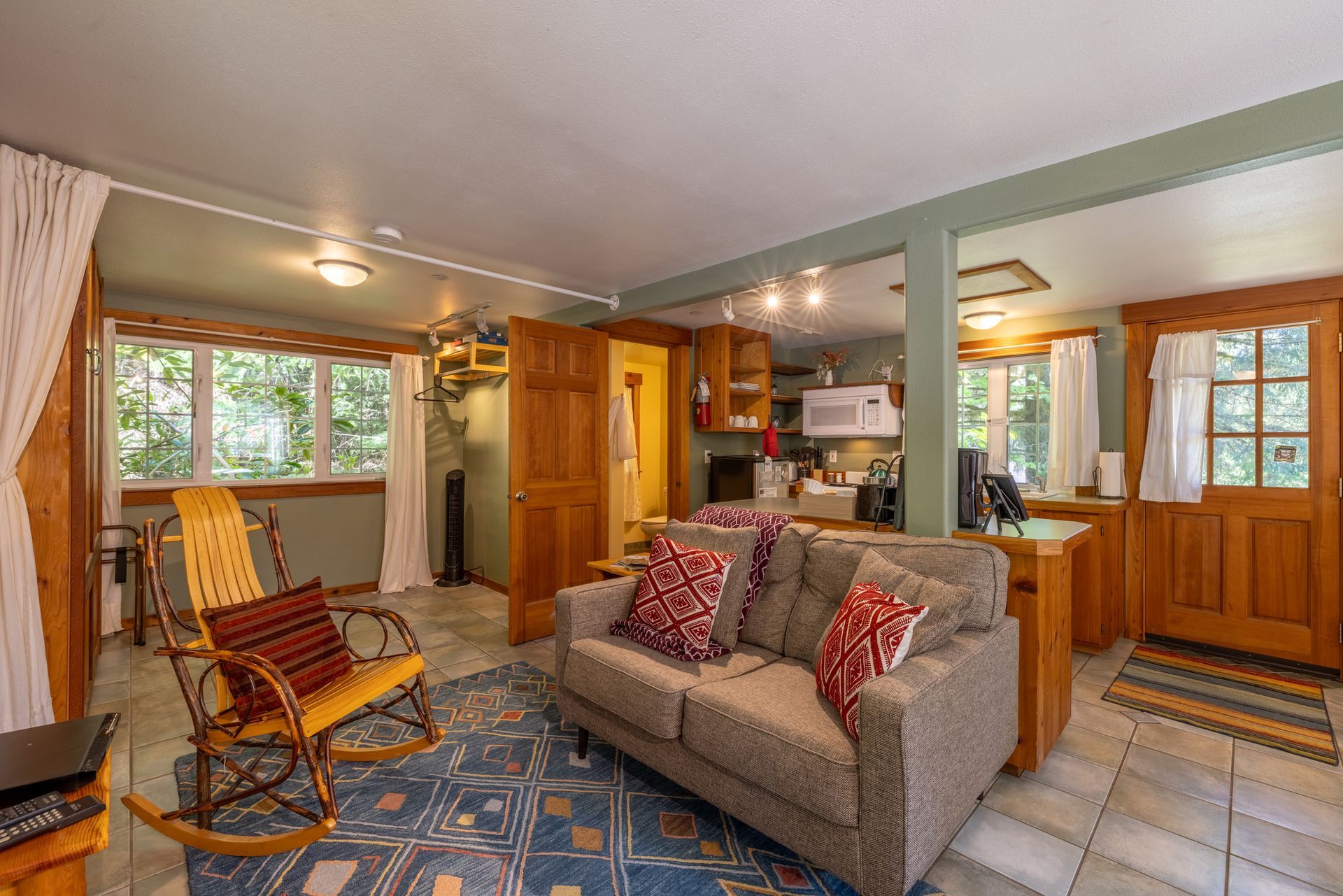 A living room with a couch , chair , table and bed.