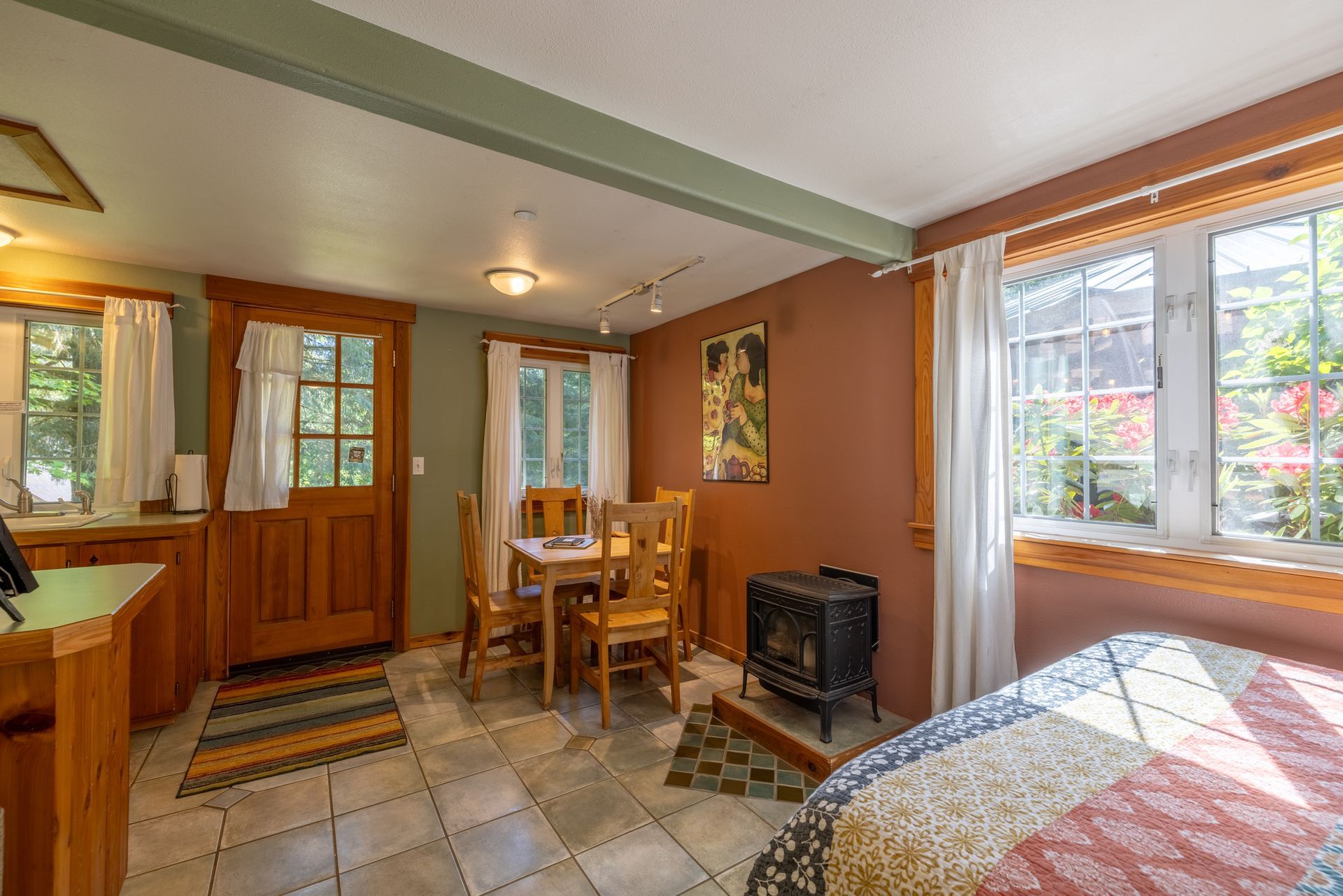 A bedroom with a bed and a window with trees in the background