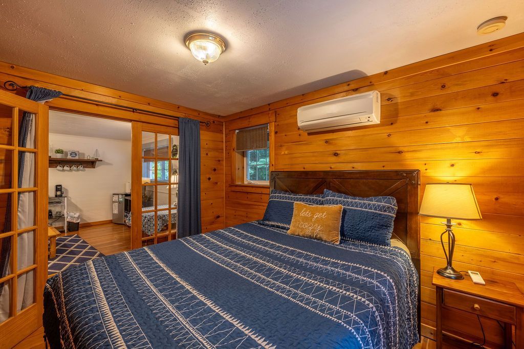 A bedroom with a bed and a sliding glass door.