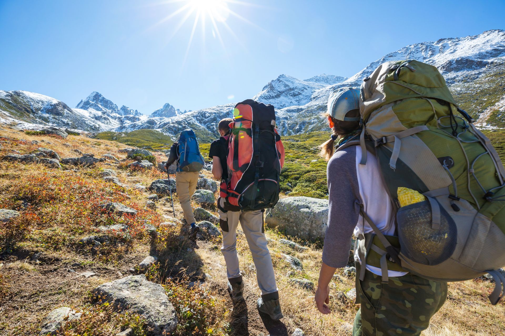 A group of people with backpacks are hiking in the mountains.