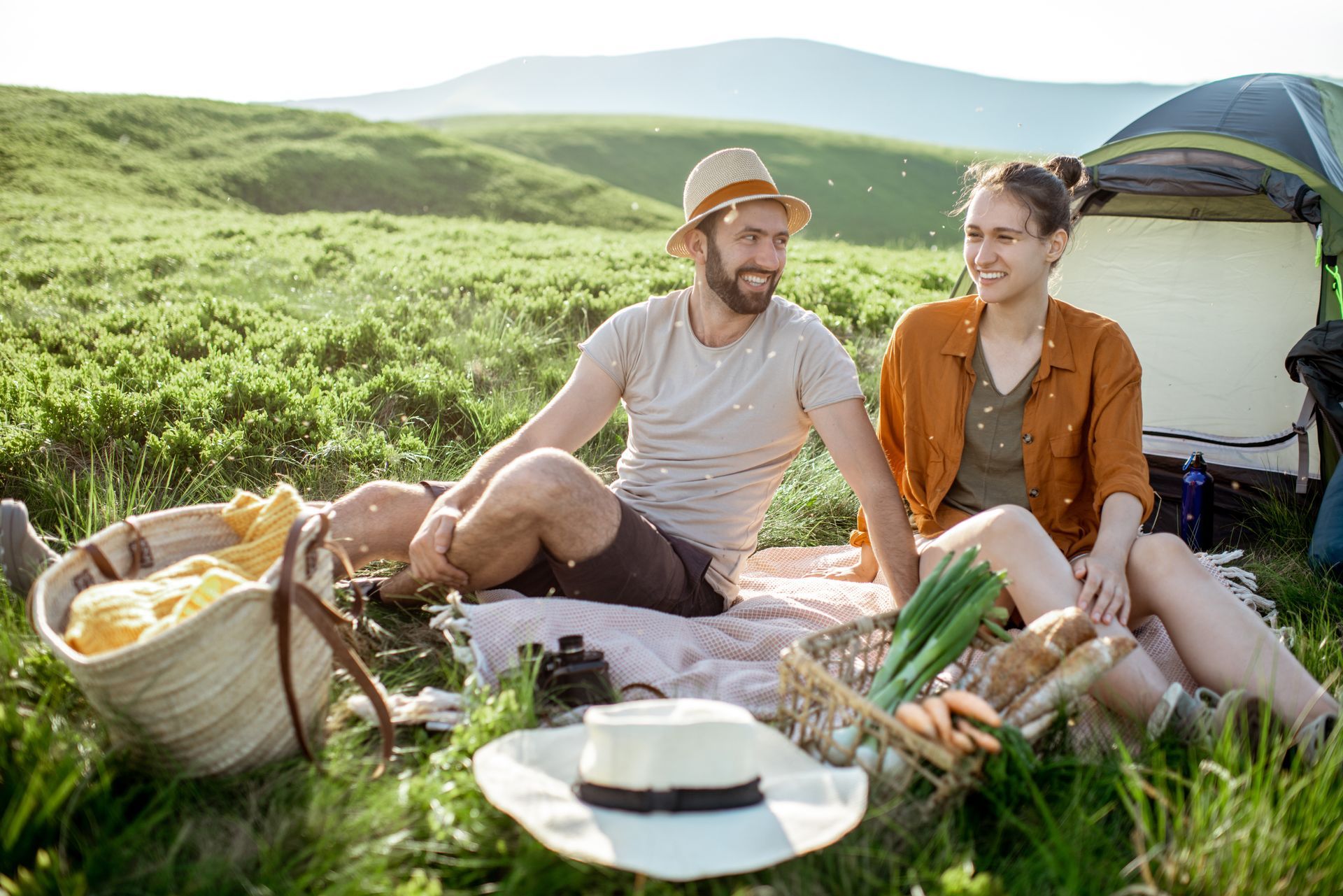 A man and a woman are having a picnic in the grass.