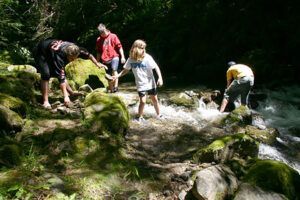 A group of people are standing on rocks near a river.