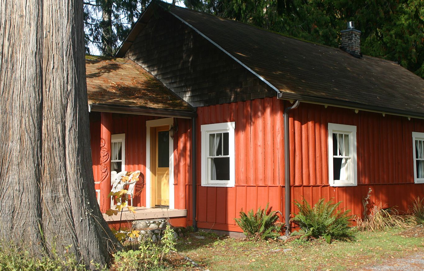 A red house with a tree in front of it