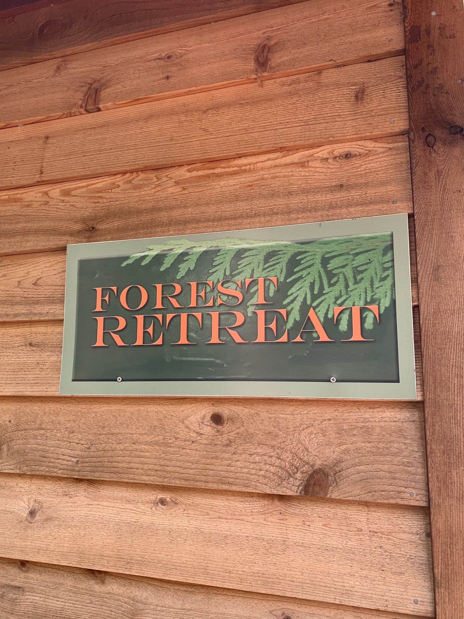A sign on a wooden wall that says forest retreat
