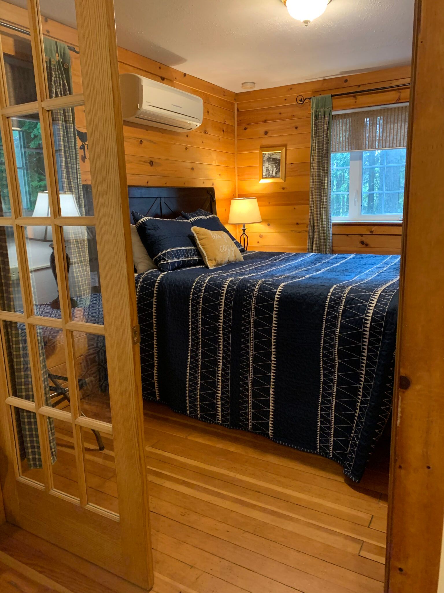 A bedroom with a bed and a sliding glass door.