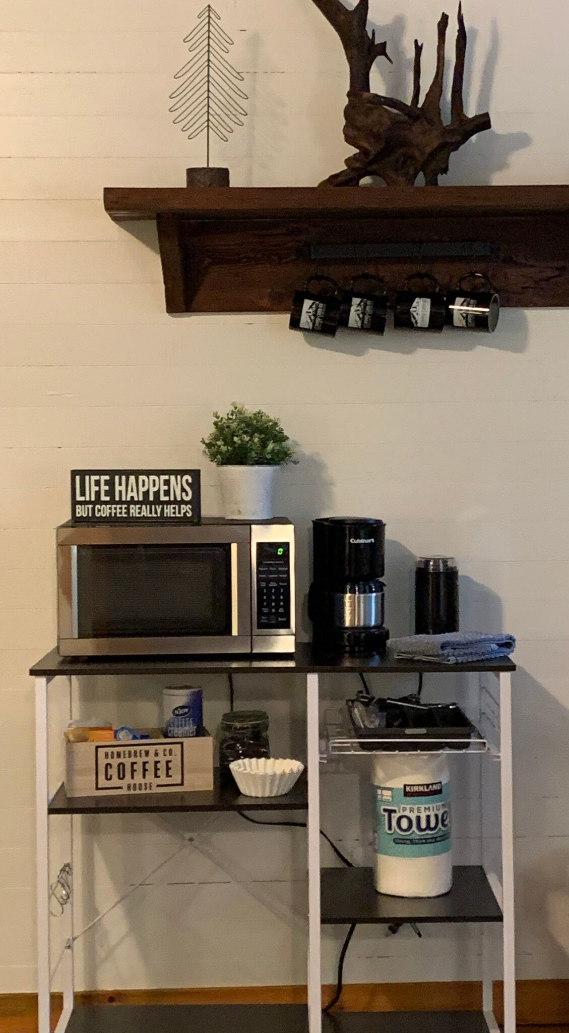 A kitchen counter with a microwave , coffee maker , and a sign that says ute happens.