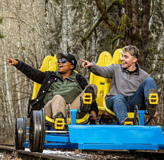 Two men are riding a blue and yellow vehicle on a track.