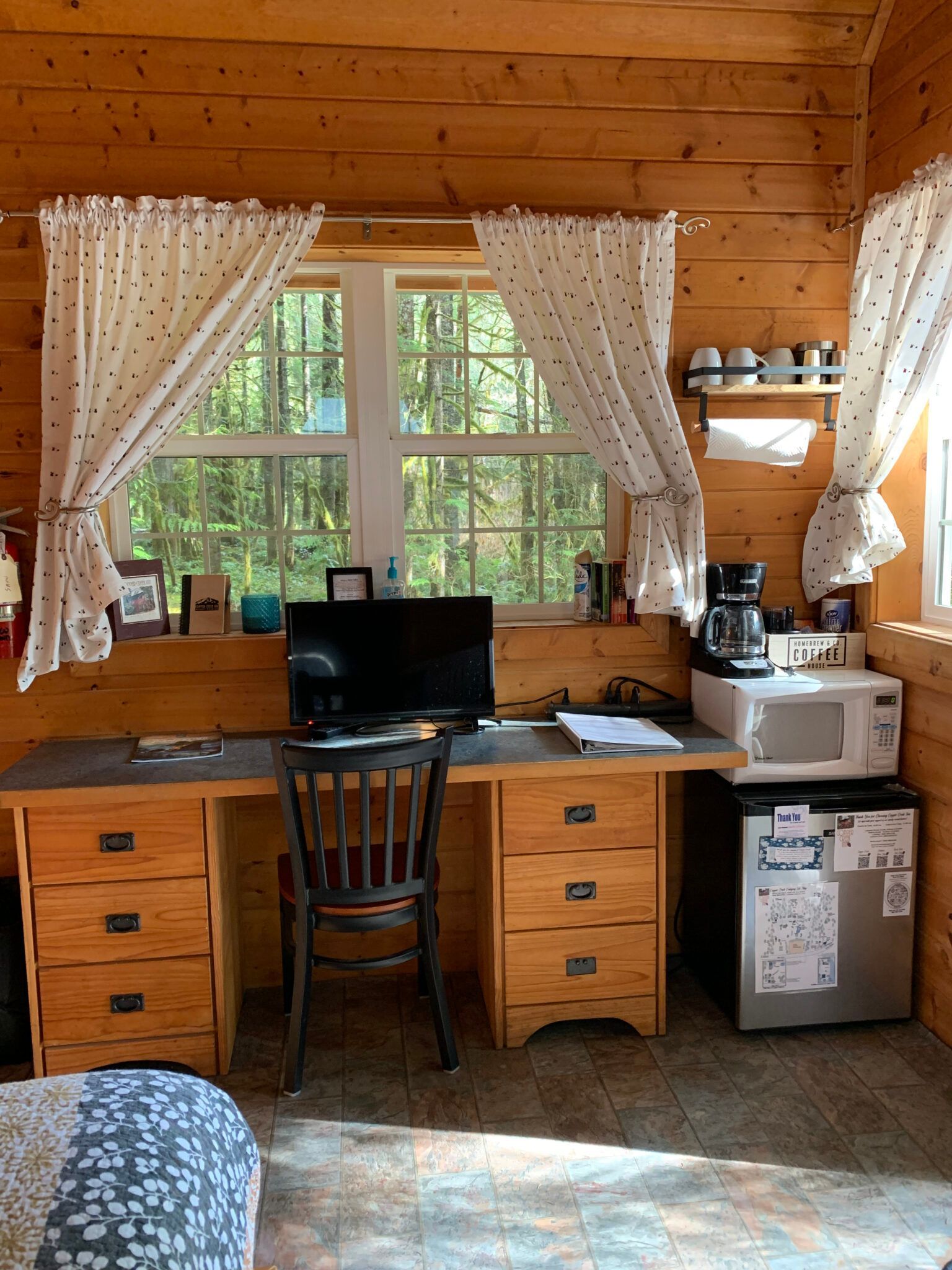 A wooden desk with a computer on it in a cabin