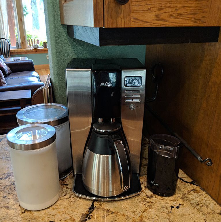A stainless steel coffee maker is sitting on a kitchen counter