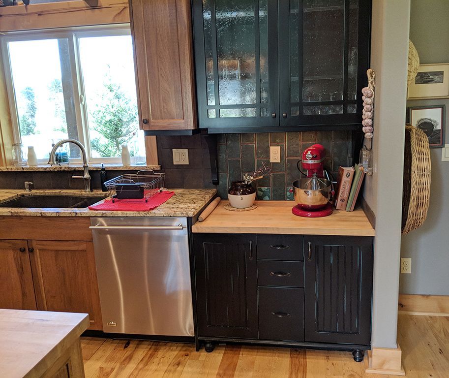 A kitchen with black cabinets and stainless steel appliances