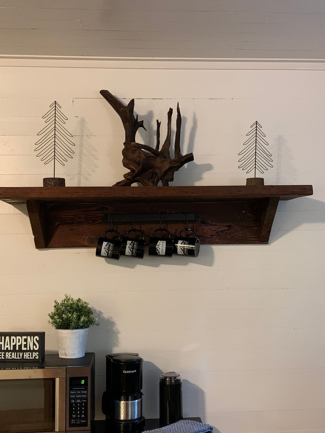 A wooden shelf with a tree on top of it in a kitchen.