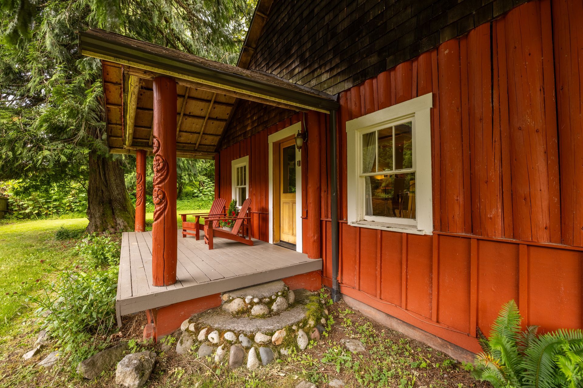 A red house with a tree in front of it