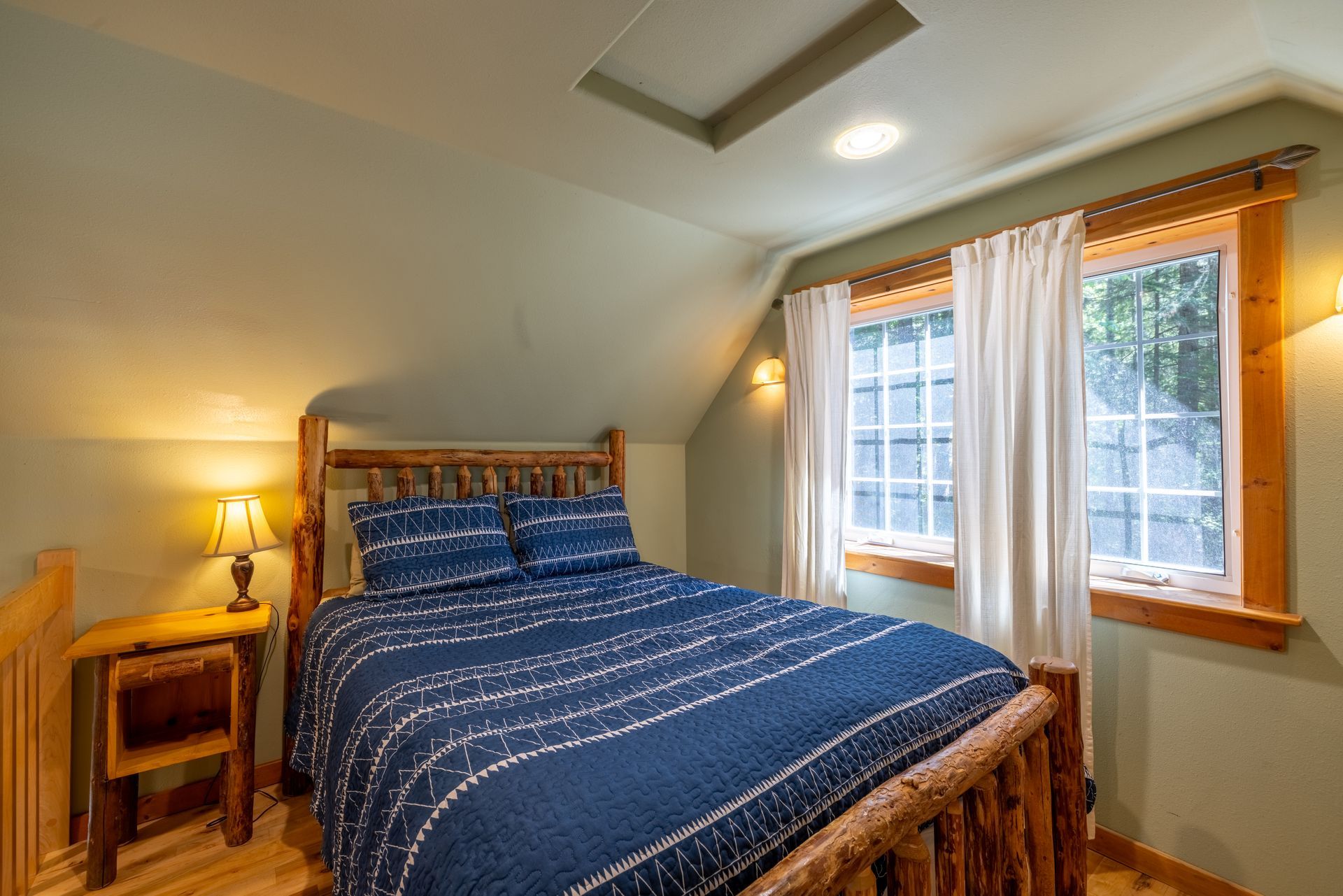 A bedroom with a log bed and a window