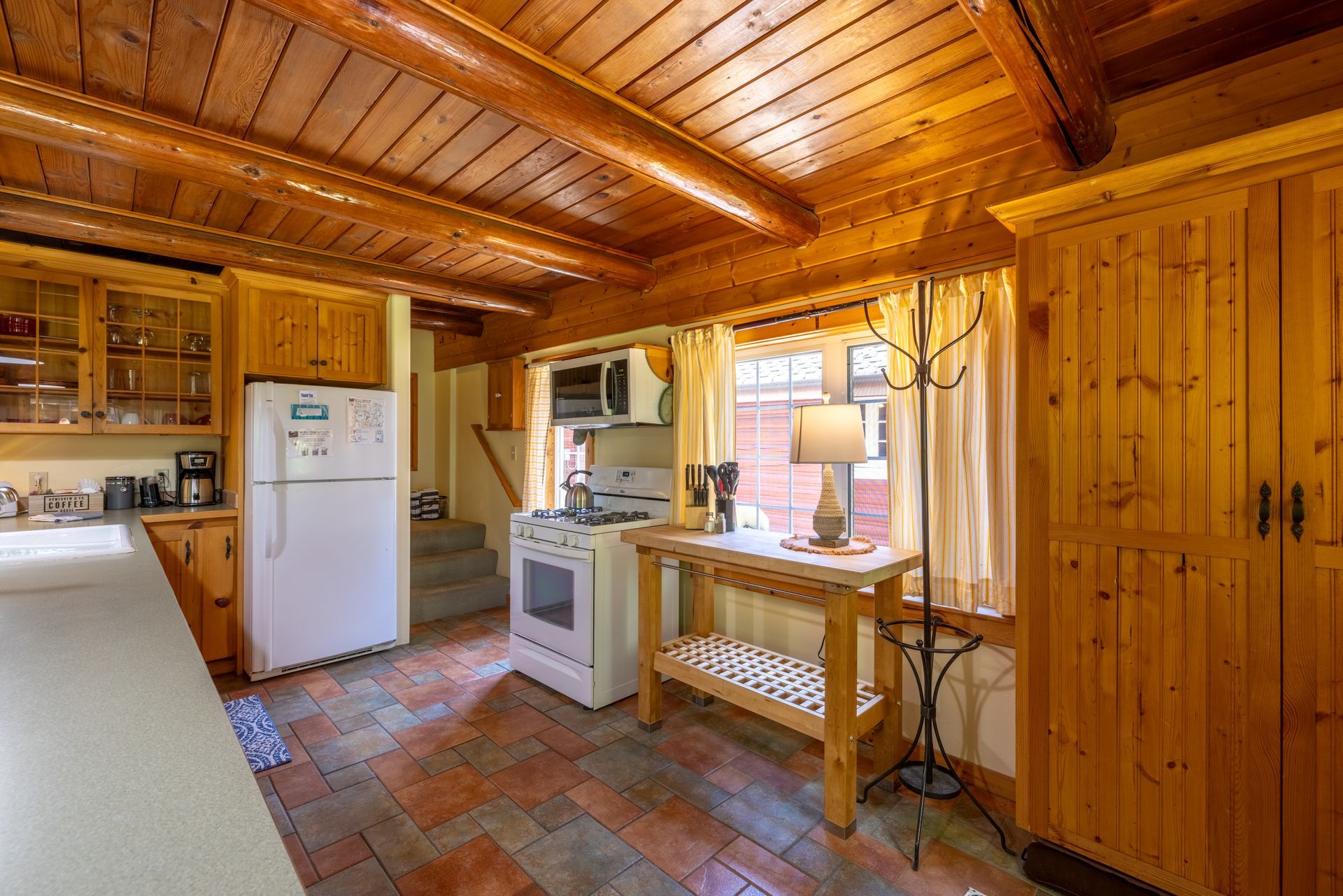 A kitchen with a stove a refrigerator and a microwave