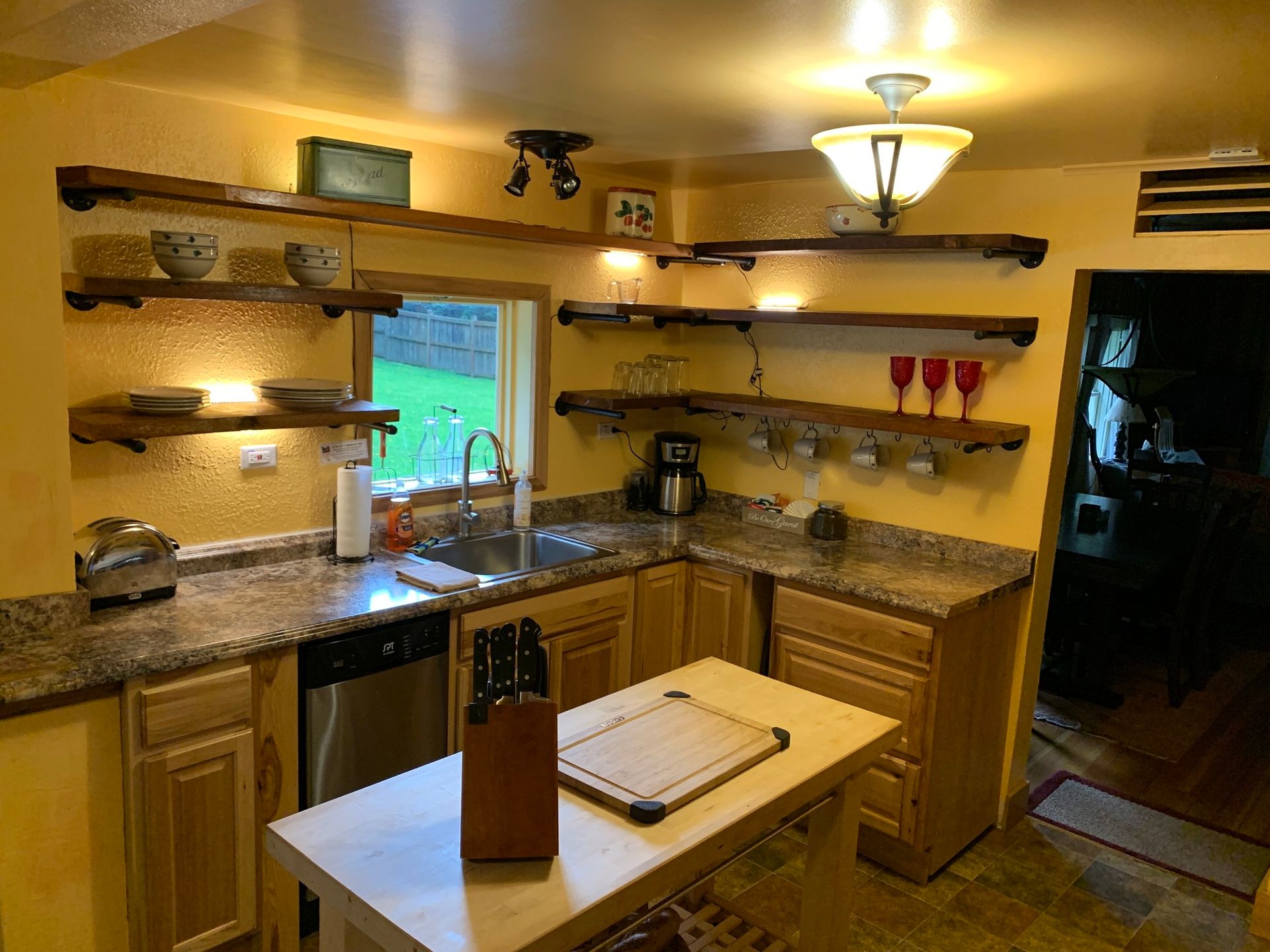 A kitchen with a sink and a cutting board on the counter