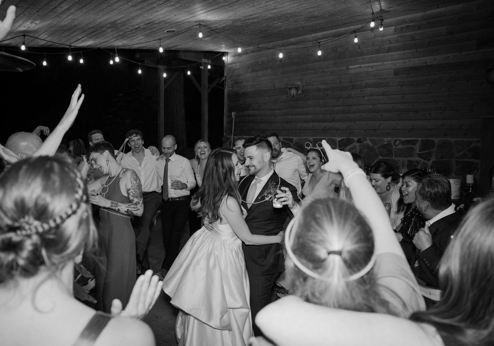 A black and white photo of a bride and groom dancing at a wedding reception.
