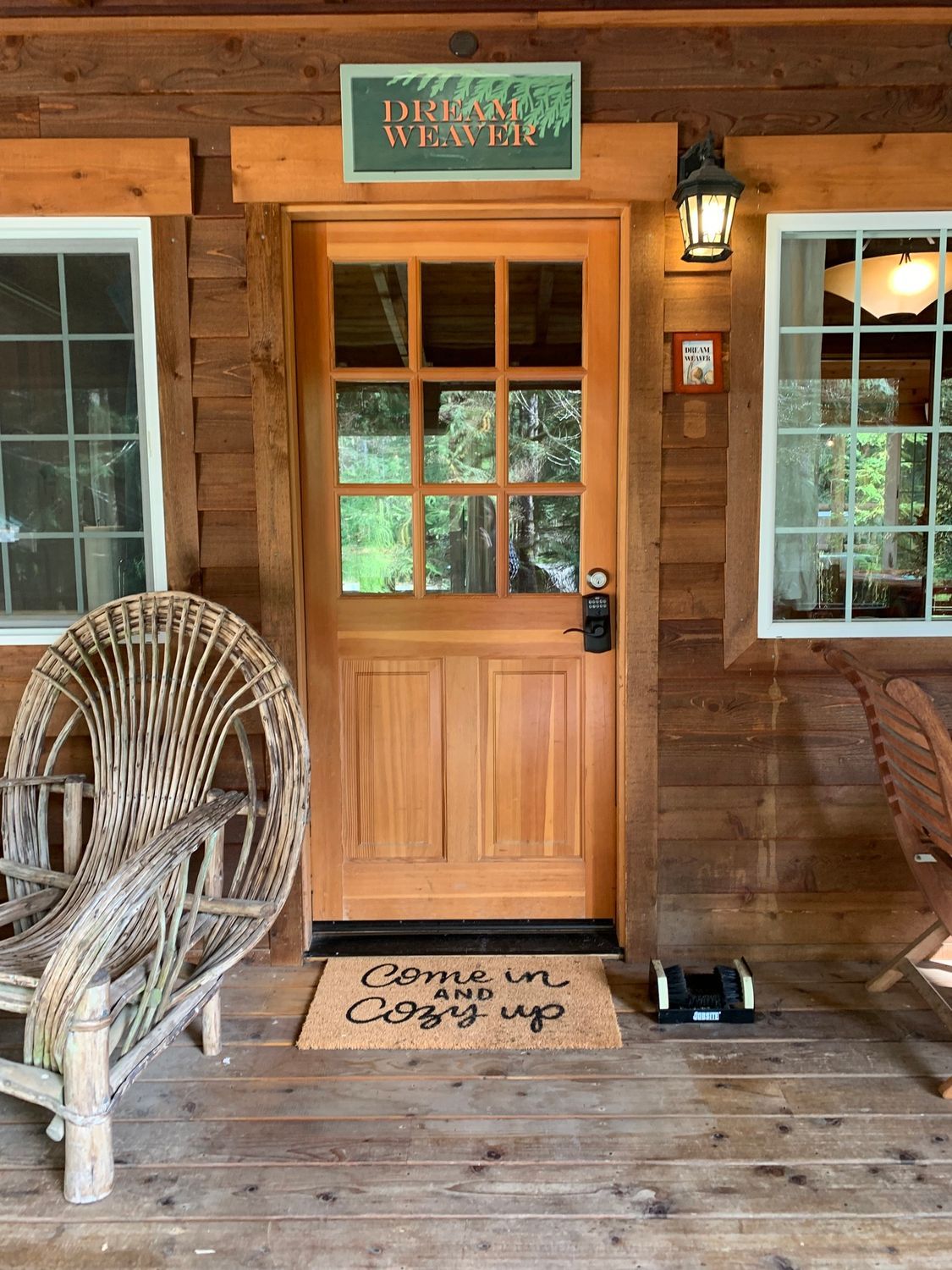 A wooden porch with wicker chairs and a door.
