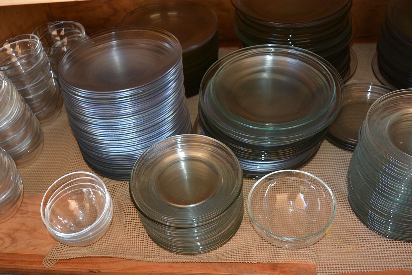 A shelf with plates and bowls stacked on top of each other
